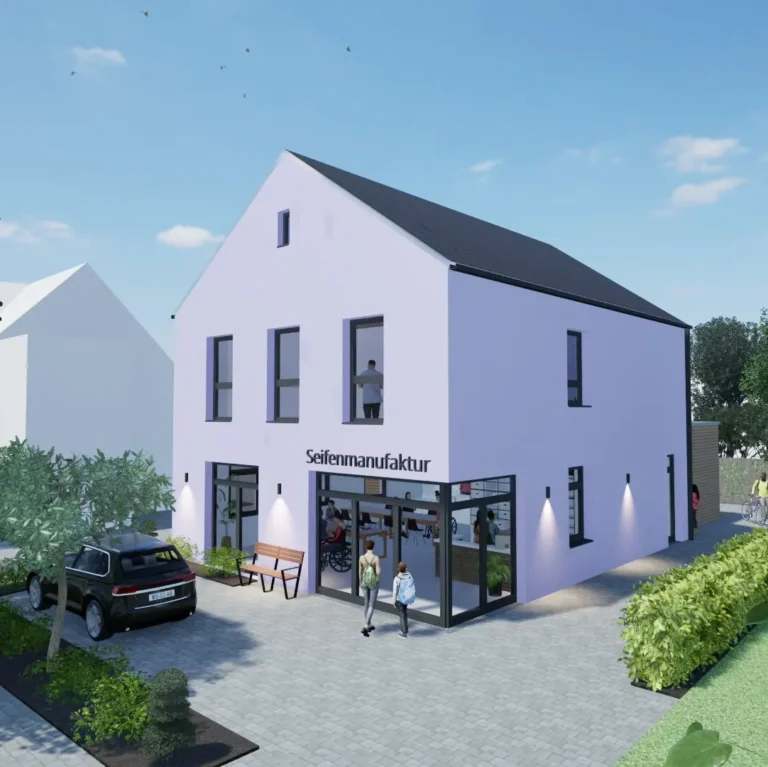 Ein modernes zweistöckiges weißes Gebäude mit großen Fenstern und einem Schild der Seifenmanufaktur, umgeben von Grün, geparkten Autos und Spaziergängern an einem sonnigen Tag.